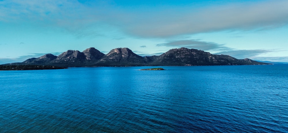 a large body of water with mountains in the background