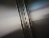 Close-up of a polished stainless steel elevator cabin reflecting soft light.
