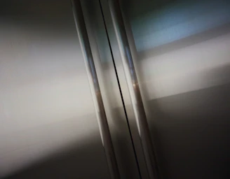 Close-up of a polished stainless steel elevator cabin interior reflecting soft ambient light.