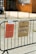 Two signs are attached to a black metal fence. The first sign on the left is orange and details opening times on Tuesday, Wednesday, Thursday, and Saturday. The second sign on the right is cardboard, labeled for donations to Ukraine. The background features a brick building and a parked car.