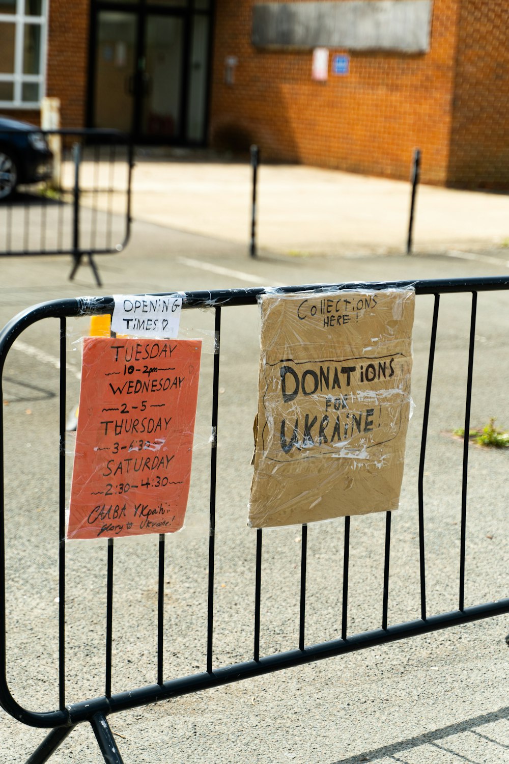 a metal fence with two signs attached to it