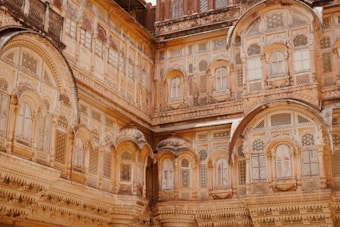 An intricately designed architectural facade featuring numerous arched windows and detailed carvings, showcasing traditional craftsmanship with ornate patterns.