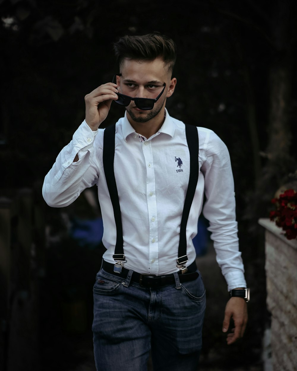 a man wearing suspenders and a white shirt