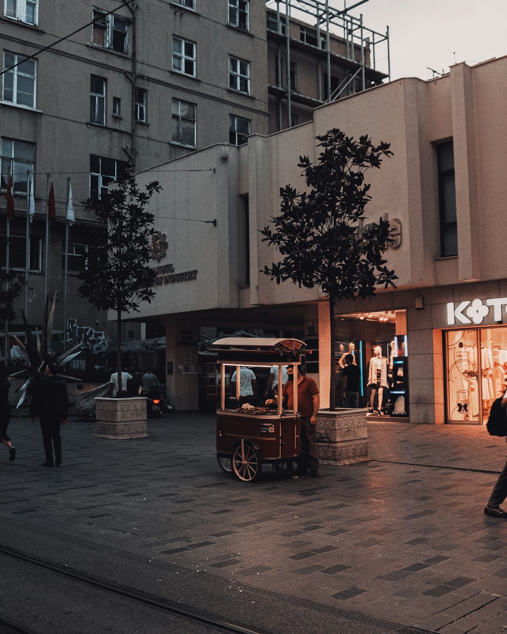 a street scene with people walking and a trolley