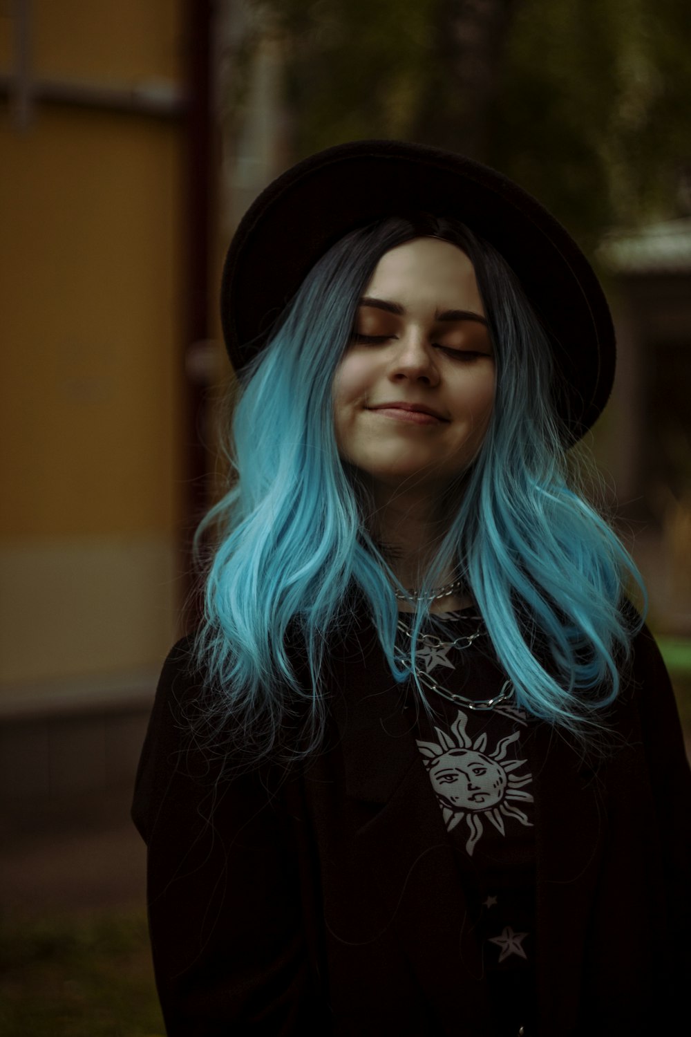 a woman with blue hair wearing a black hat