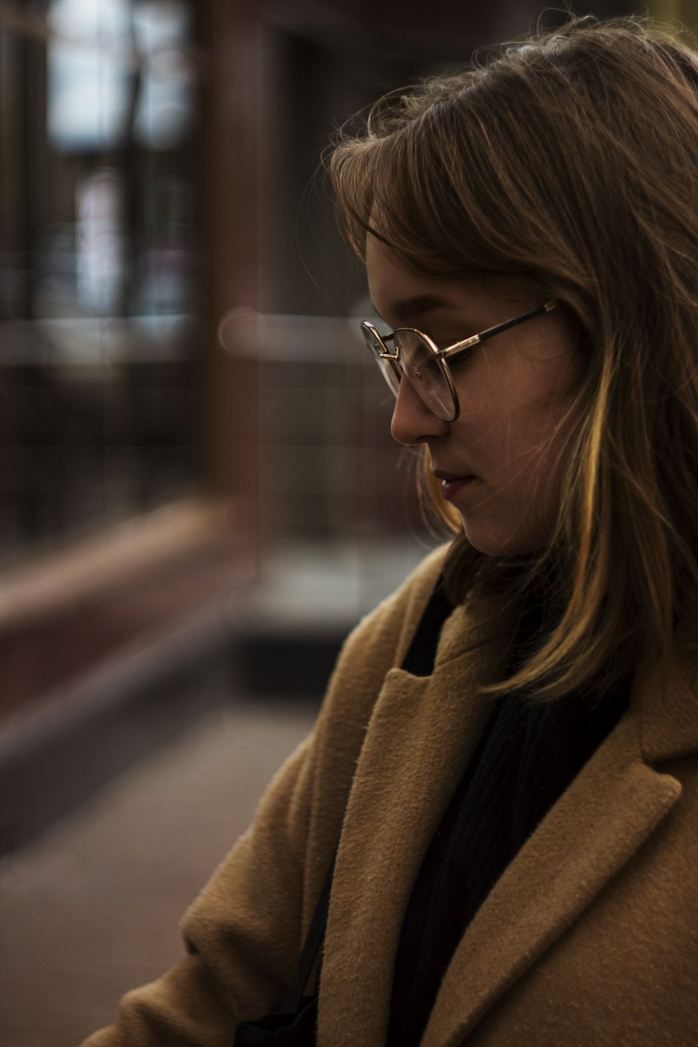 a woman with glasses looking at her cell phone