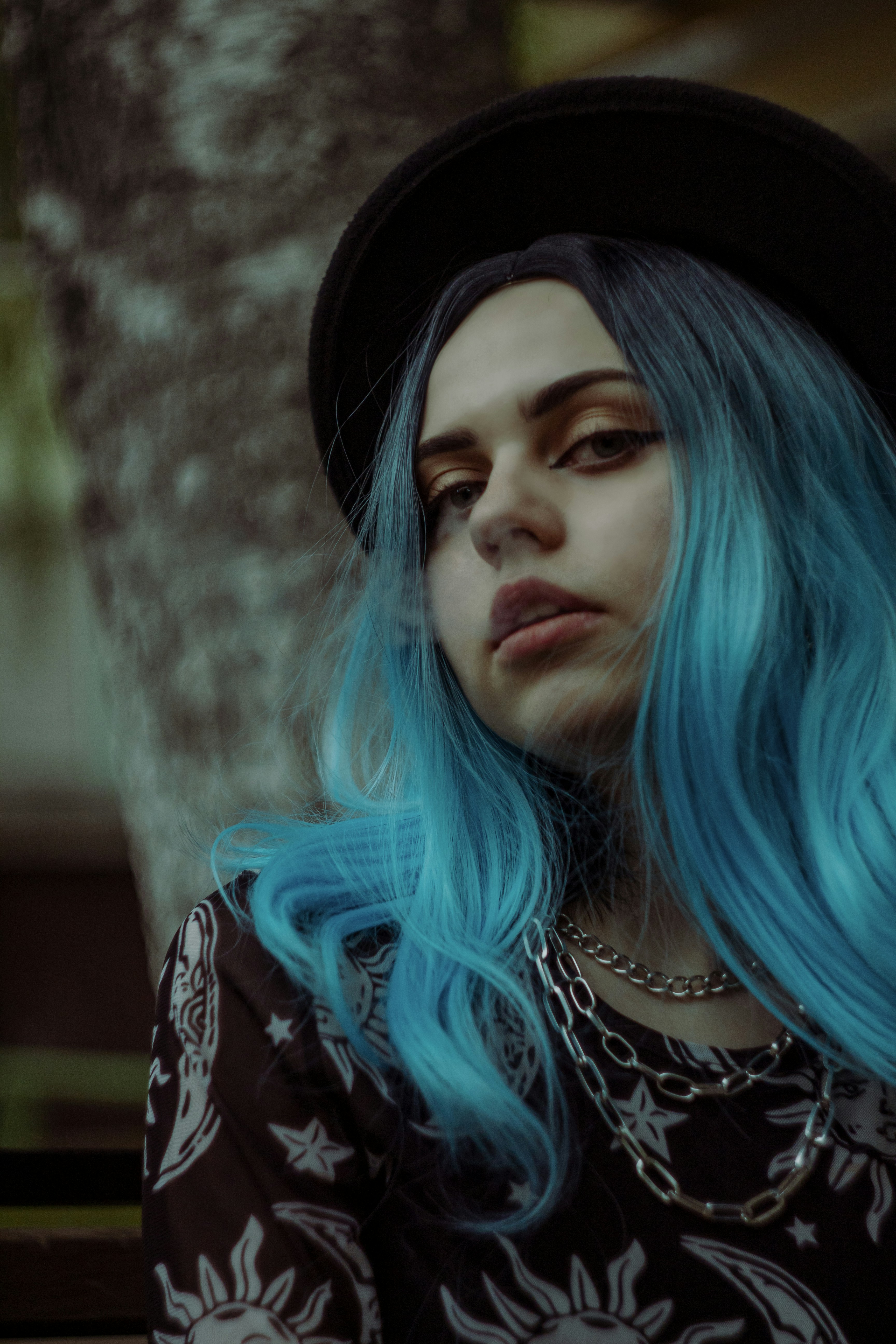Eine Frau mit blauen Haaren mit schwarzem Hut
