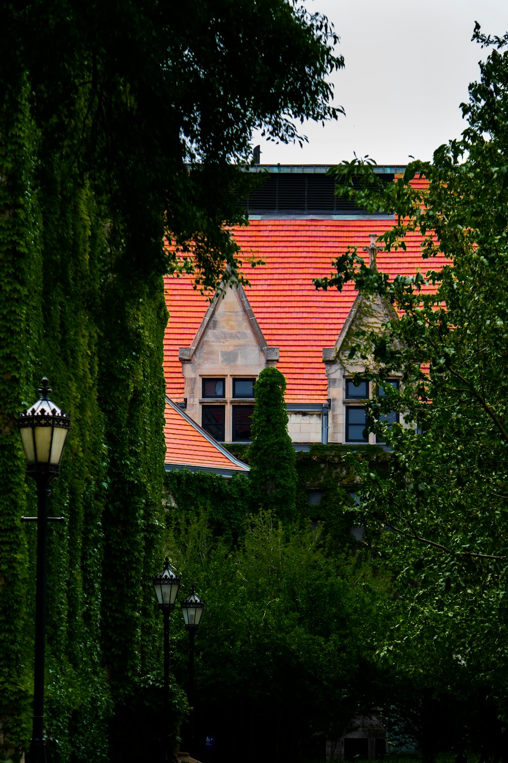 a building with a red roof is seen through the trees