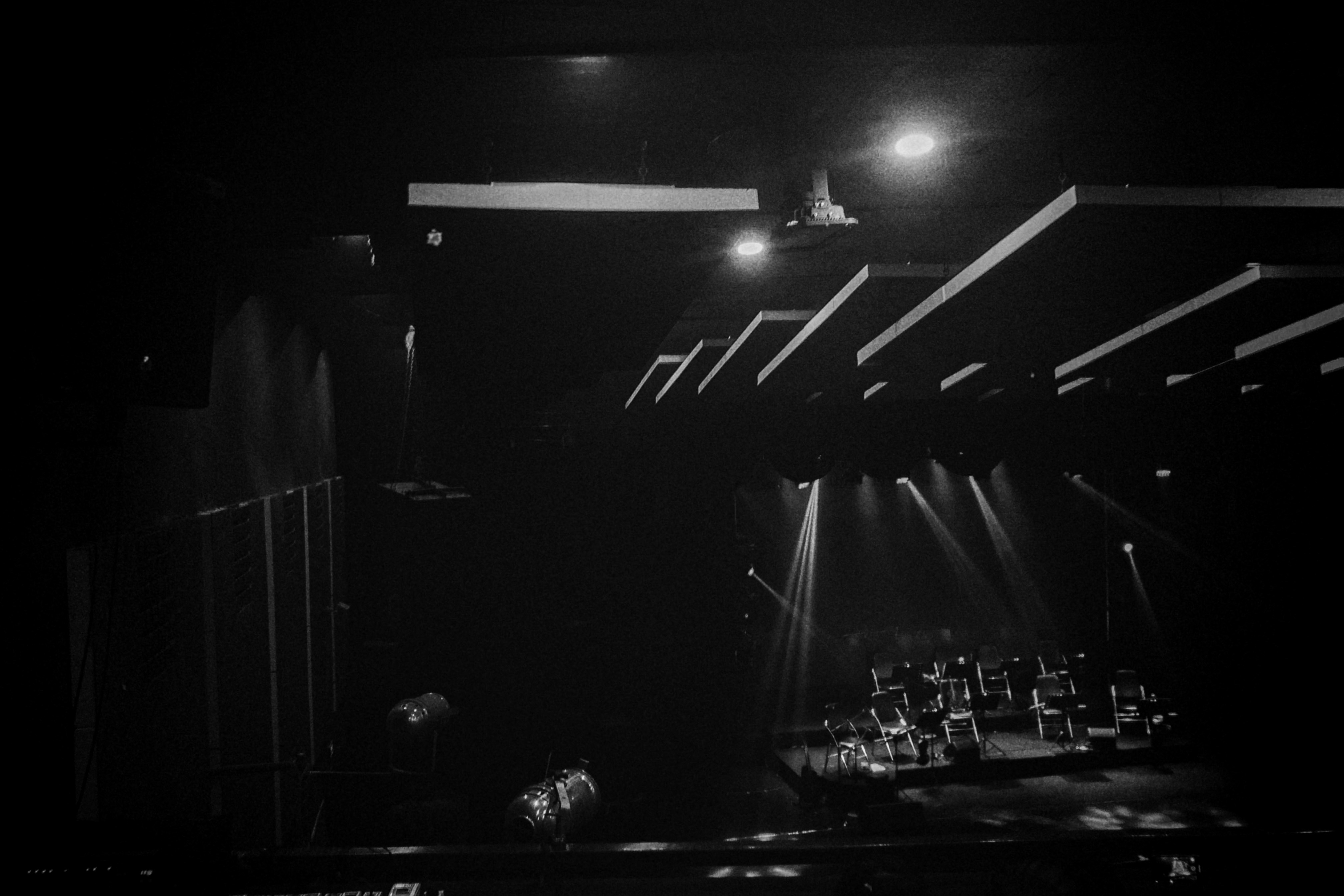 Stage spotlight on empty dark theater, dramatic shadows