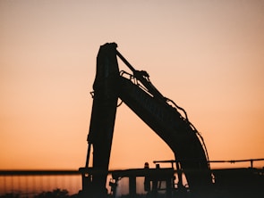 a crane is silhouetted against a sunset sky