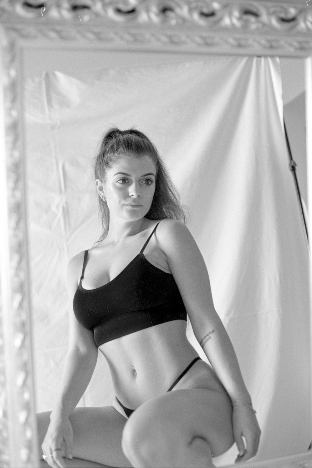 Foto Una mujer en bikini sentada en una cama frente a un espejo – Imagen  Gris gratis en Unsplash