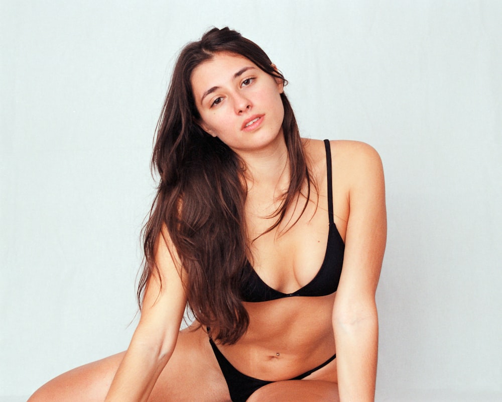 a woman in a black bikini posing for a picture