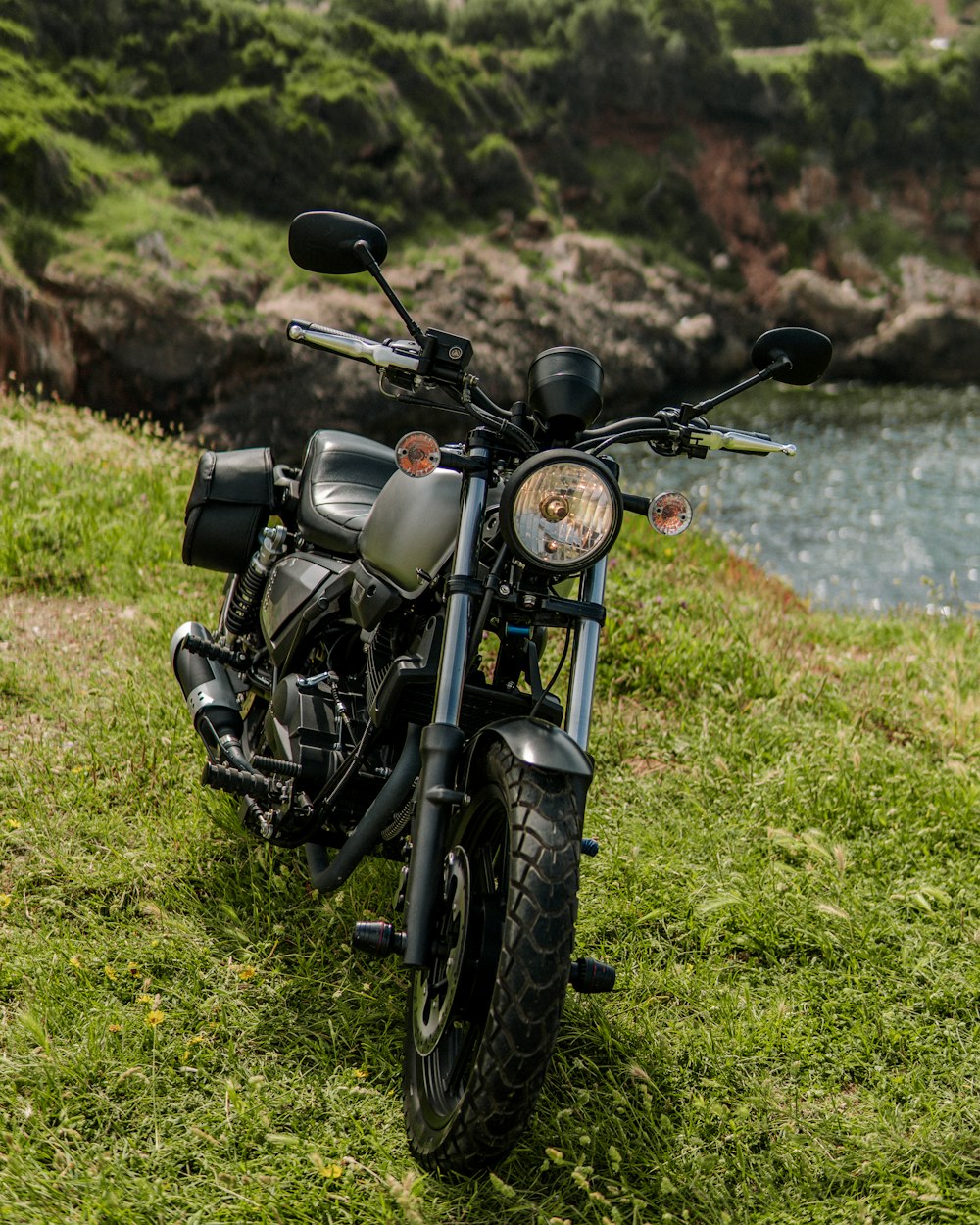 a black motorcycle parked on top of a lush green field