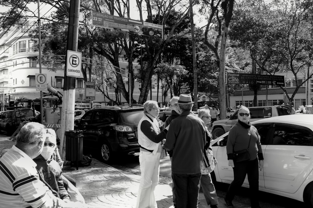 a black and white photo of people on a street corner