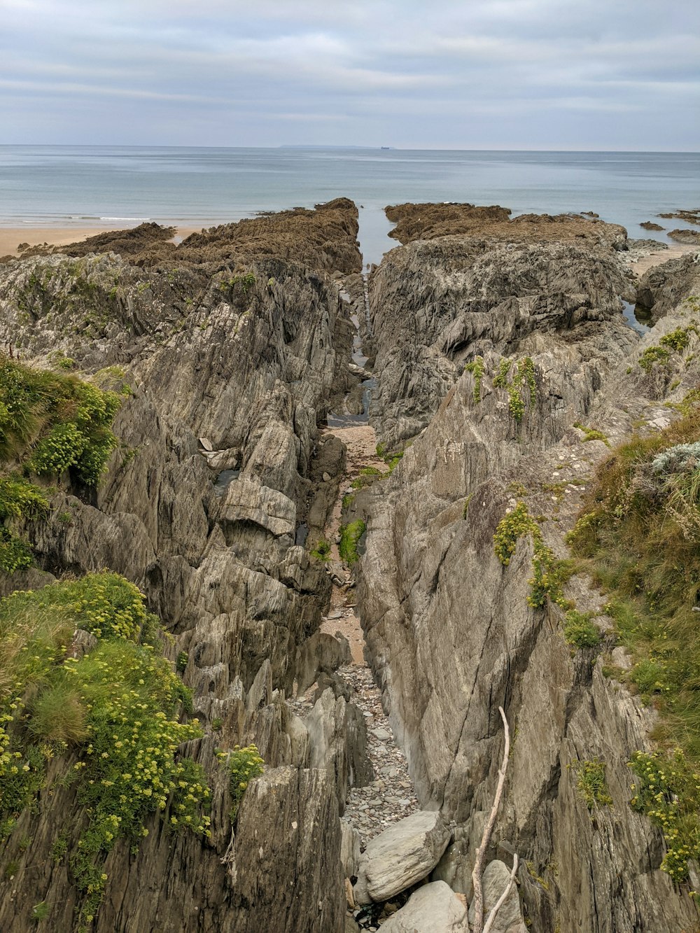 a view of a rocky cliff with a body of water in the distance