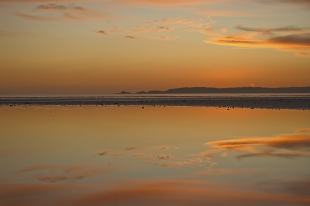 a large body of water sitting under a cloudy sky