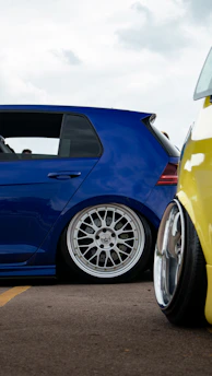 Side profile of a modified car showcasing custom wheels and lowered stance.