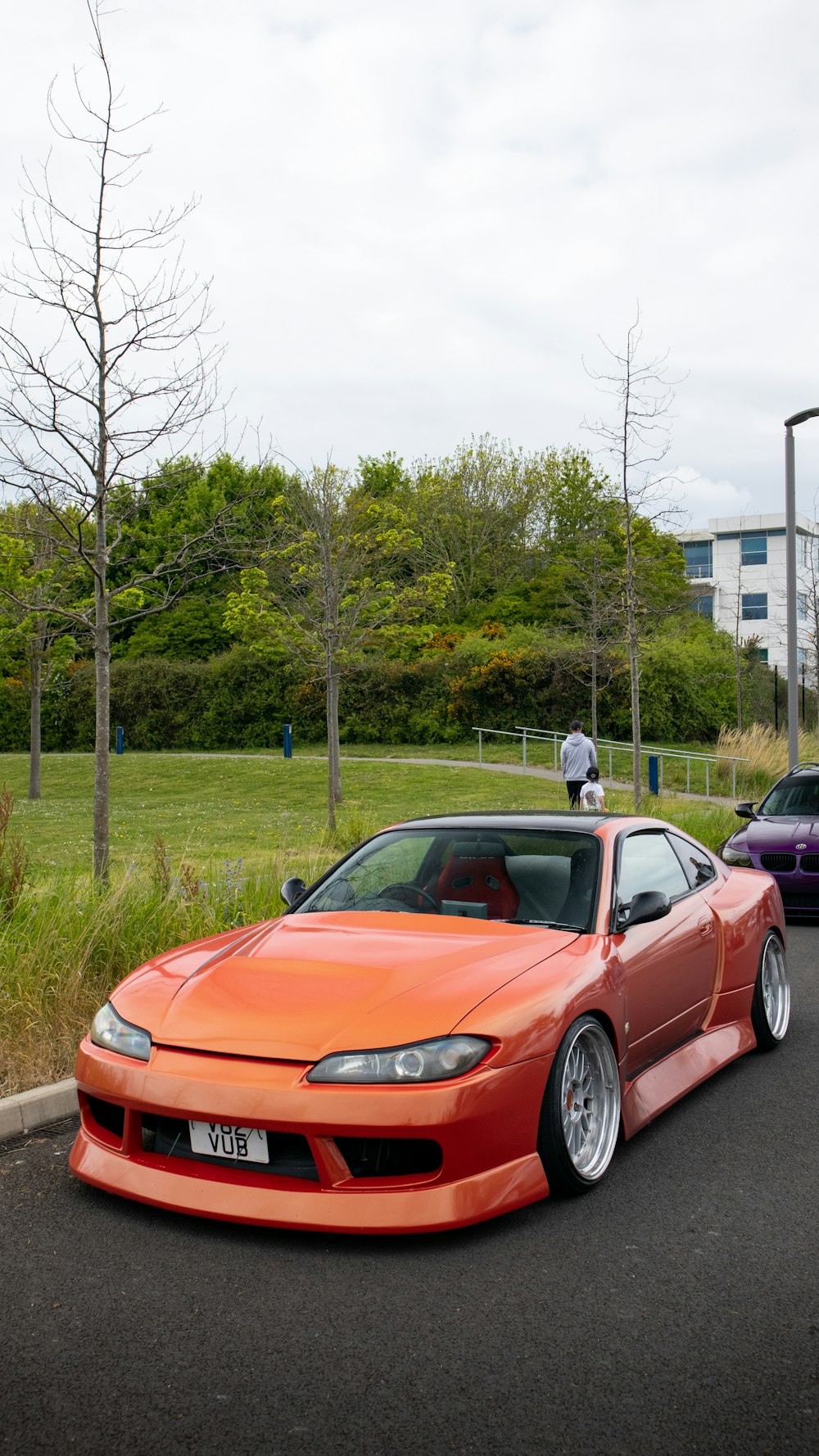 a red sports car parked next to a purple car