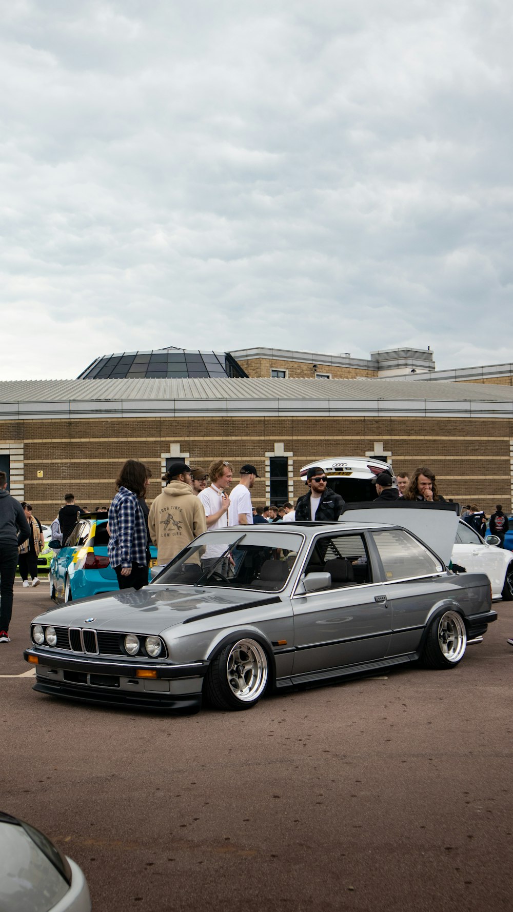 a group of people standing around a parked car