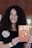 A smiling customer holding a book by H Shah.