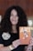 A smiling customer holding a book by H Shah.