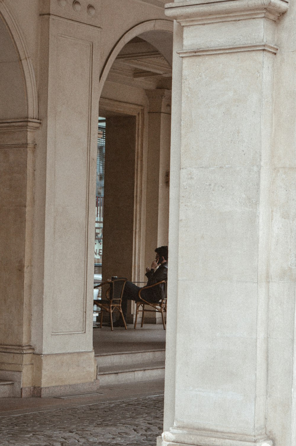 a man sitting in a chair under an archway