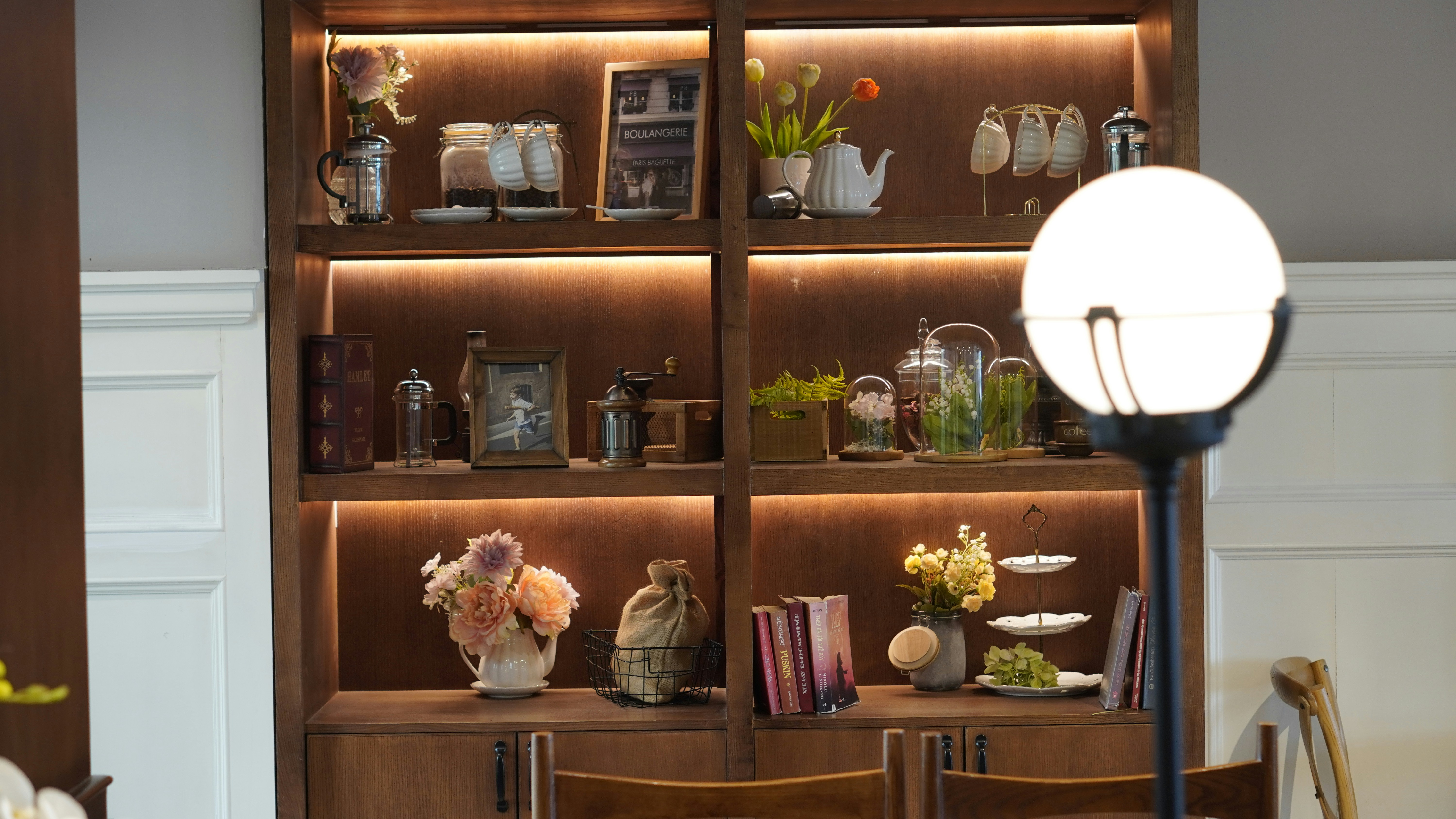a room with a book shelf and a lamp