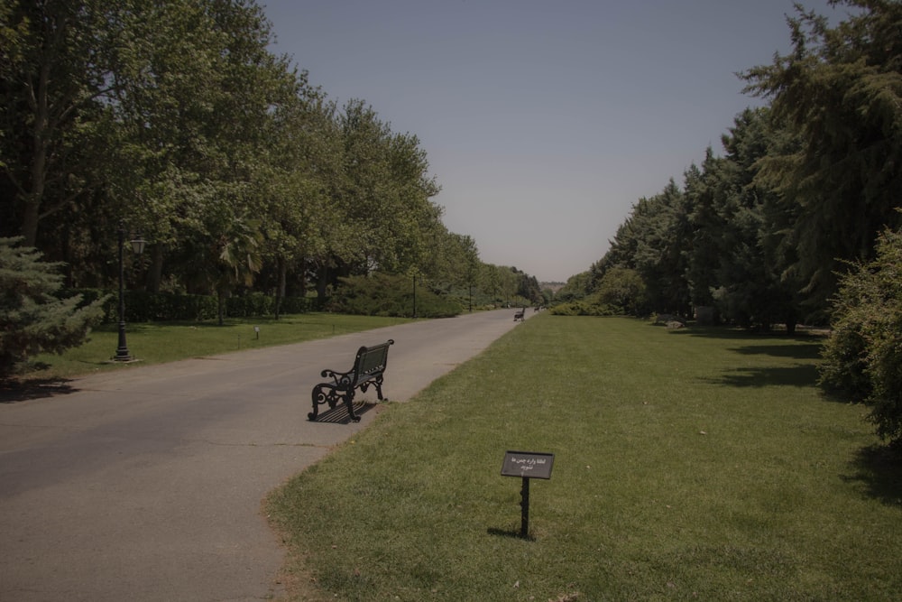 a park bench sitting on the side of a road