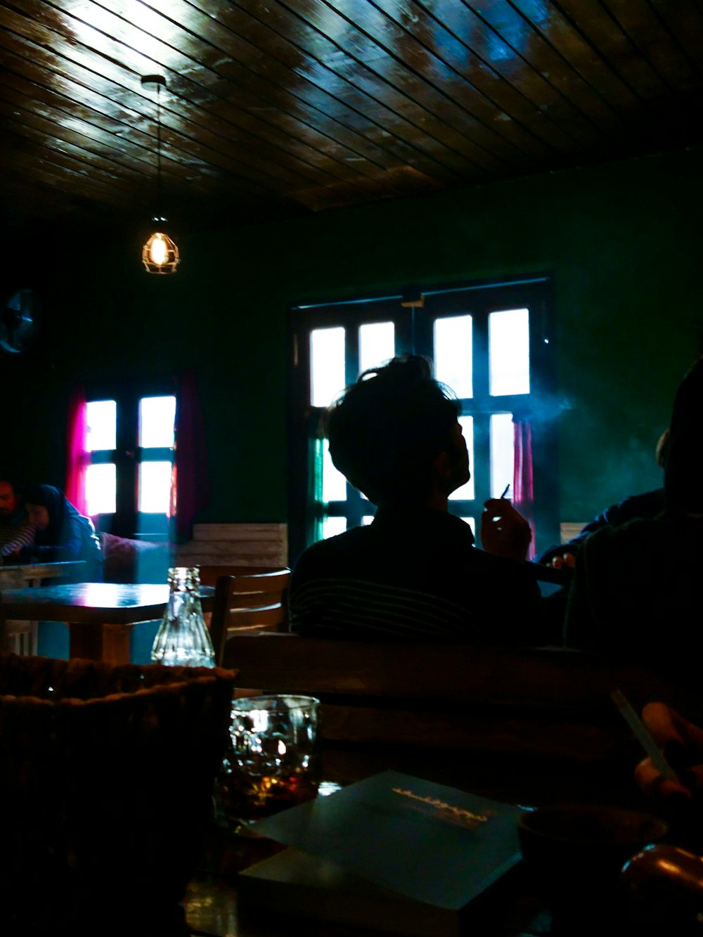 a person sitting at a table in a dark room