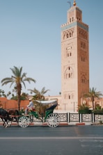 a horse drawn carriage in front of a tall tower