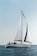 A serene view of a yacht sailing on calm blue waters under a clear sky.