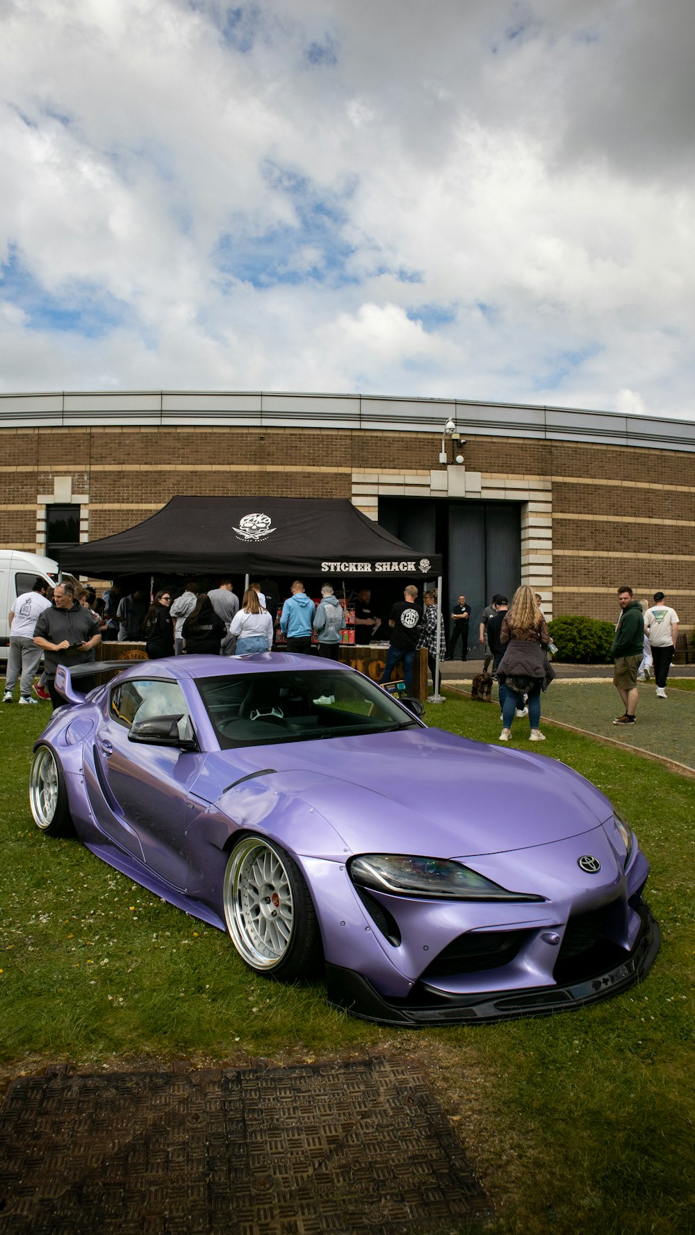 a purple sports car parked in front of a building