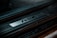A close-up view of a car door sill plate with the letters 'RSX' prominently engraved on a metallic strip. The surrounding area is a textured black surface, suggesting a sleek automotive design.