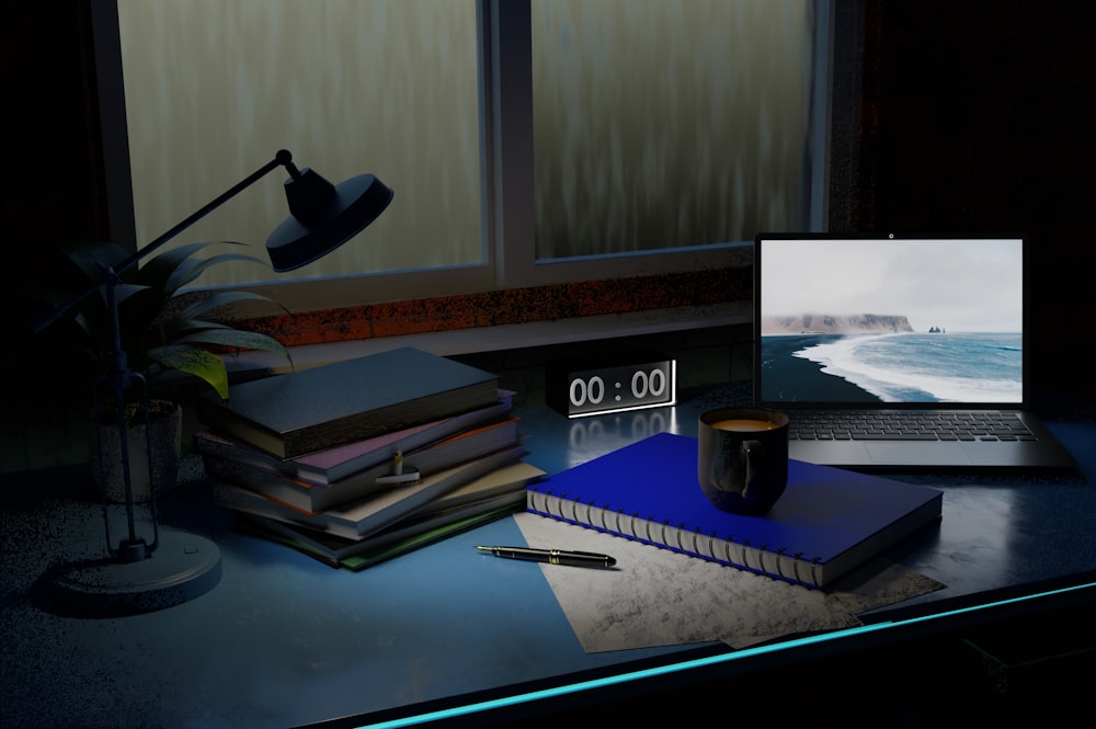 un ordinateur portable posé sur un bureau à côté d’une pile de livres