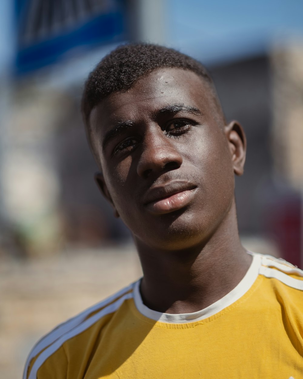 a young man in a yellow shirt posing for a picture