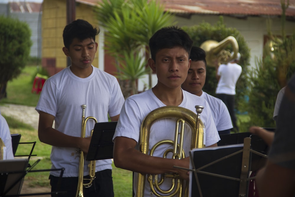 a group of young men standing next to each other holding musical instruments