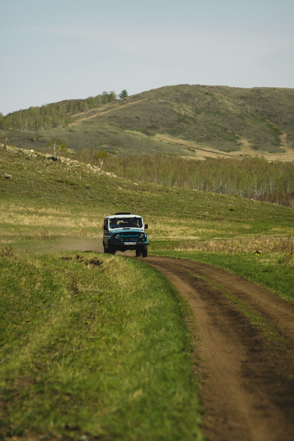 a truck is driving down a dirt road