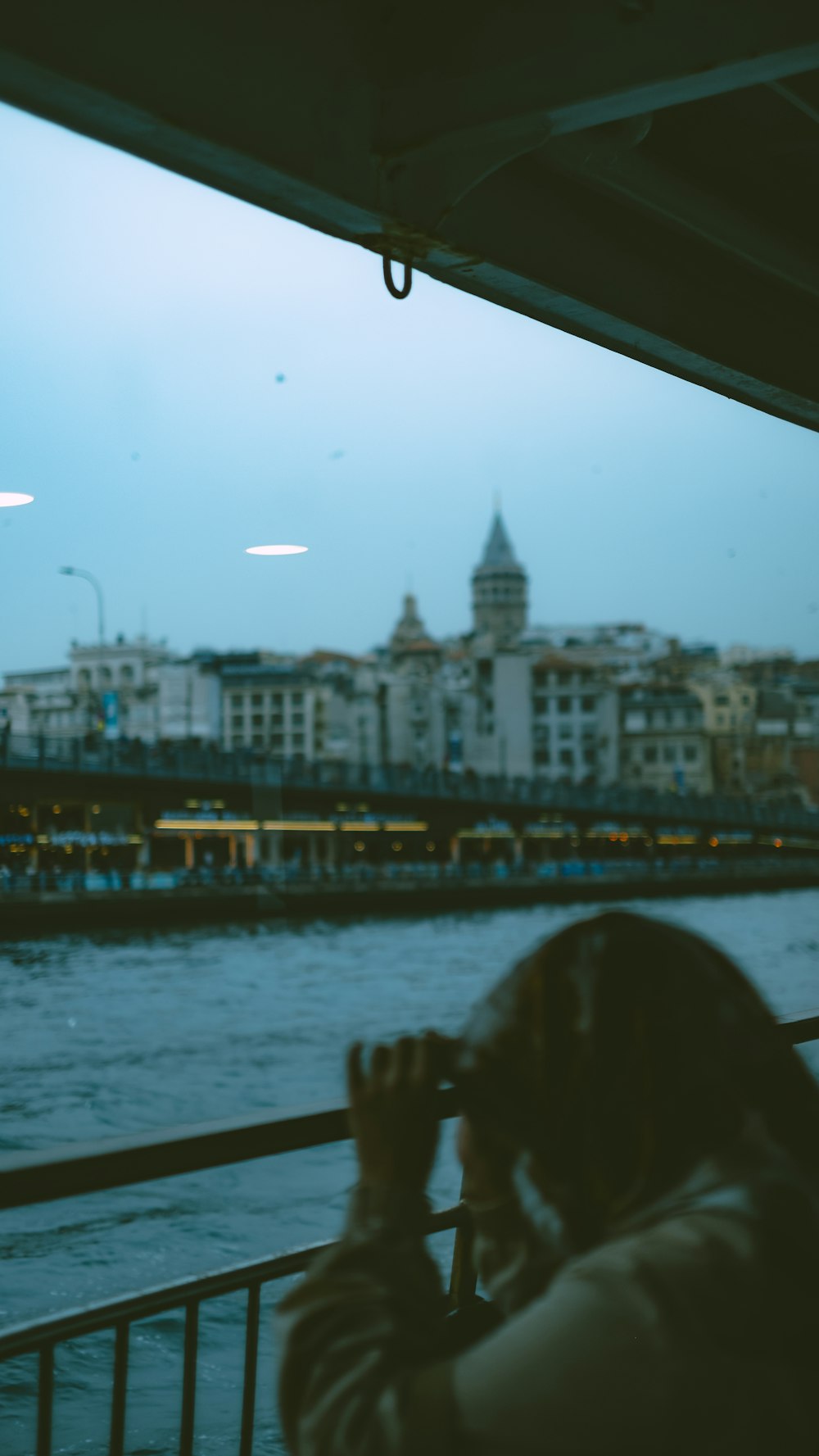 a woman looking out a window at a river