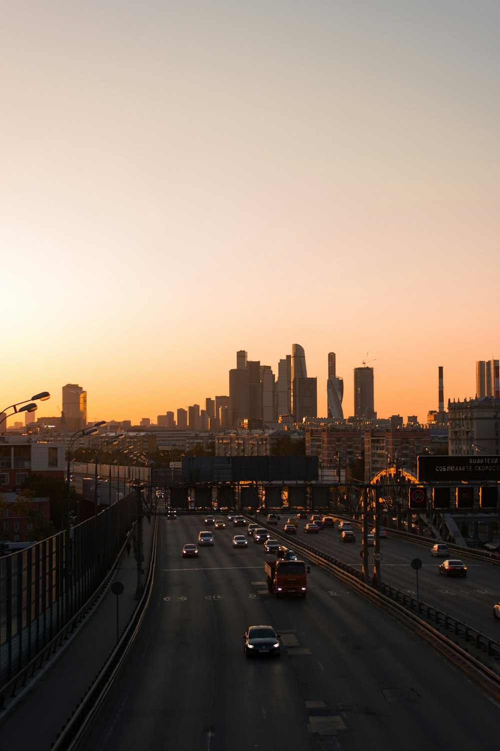 a sunset view of a highway with a city in the background