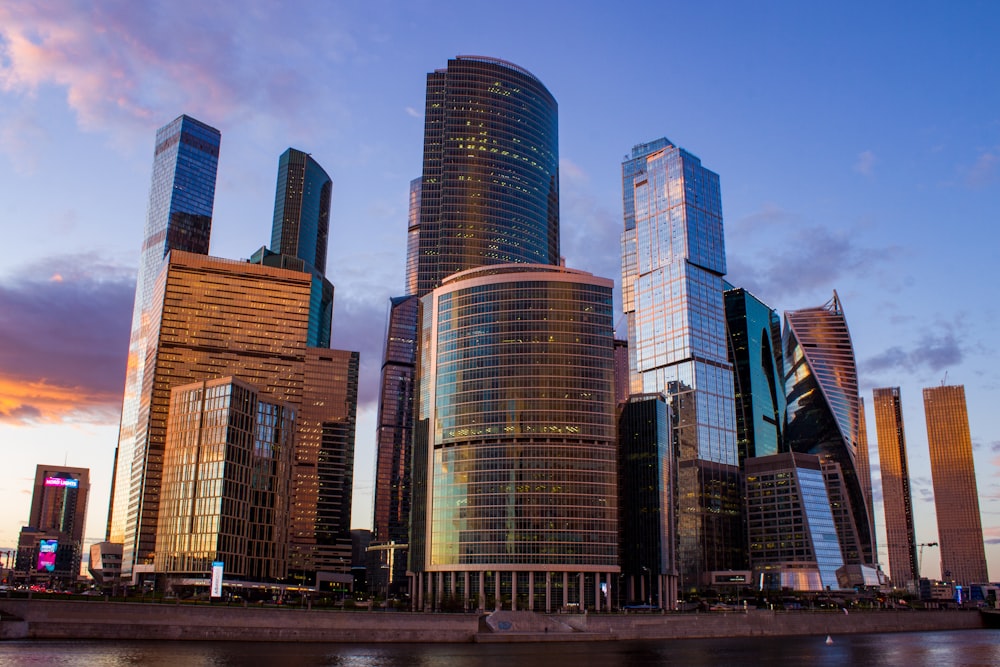 a group of tall buildings next to a body of water