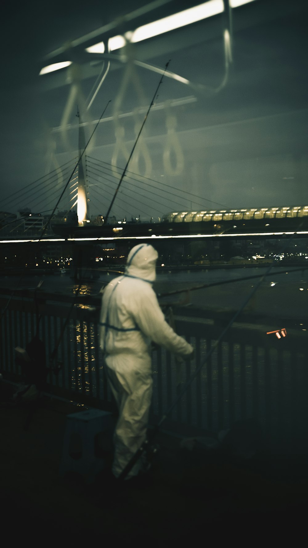 a man in a white suit is standing on a bridge