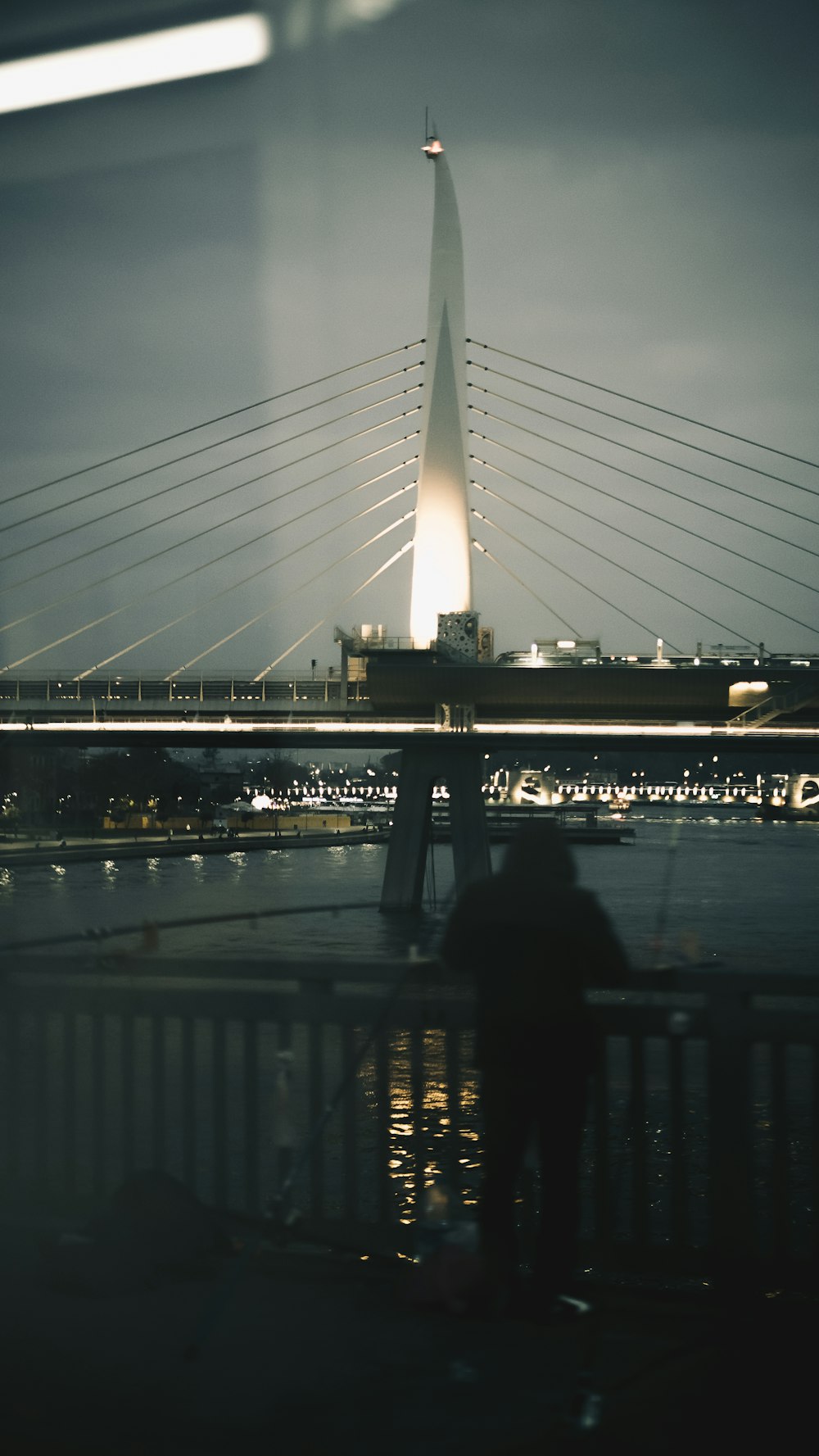 a person sitting on a bench looking at a bridge