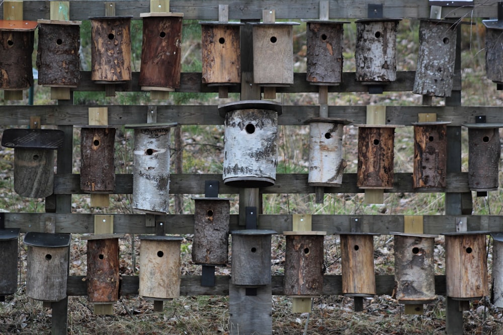 a bunch of bird houses that are on a fence