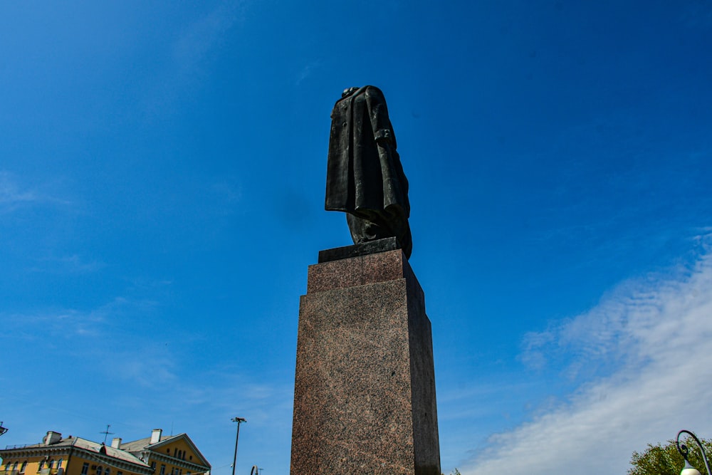 a statue of a man with a coat on top of it