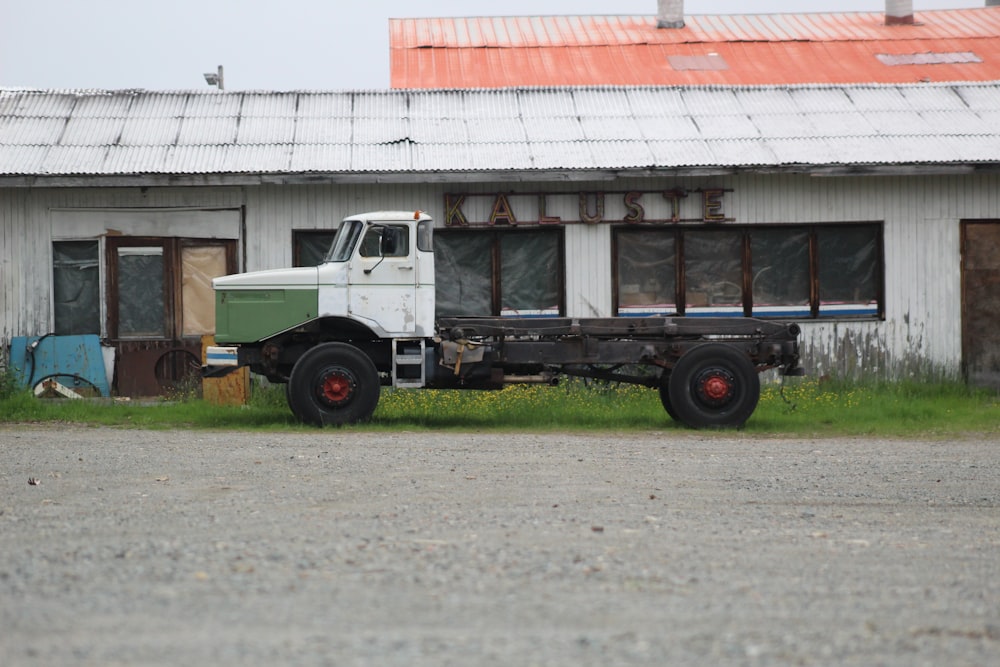 an old truck parked in front of a run down building