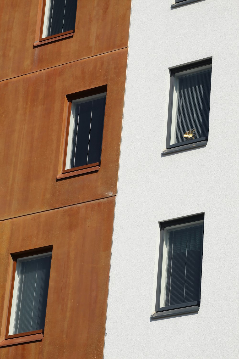 a white and brown building with three windows