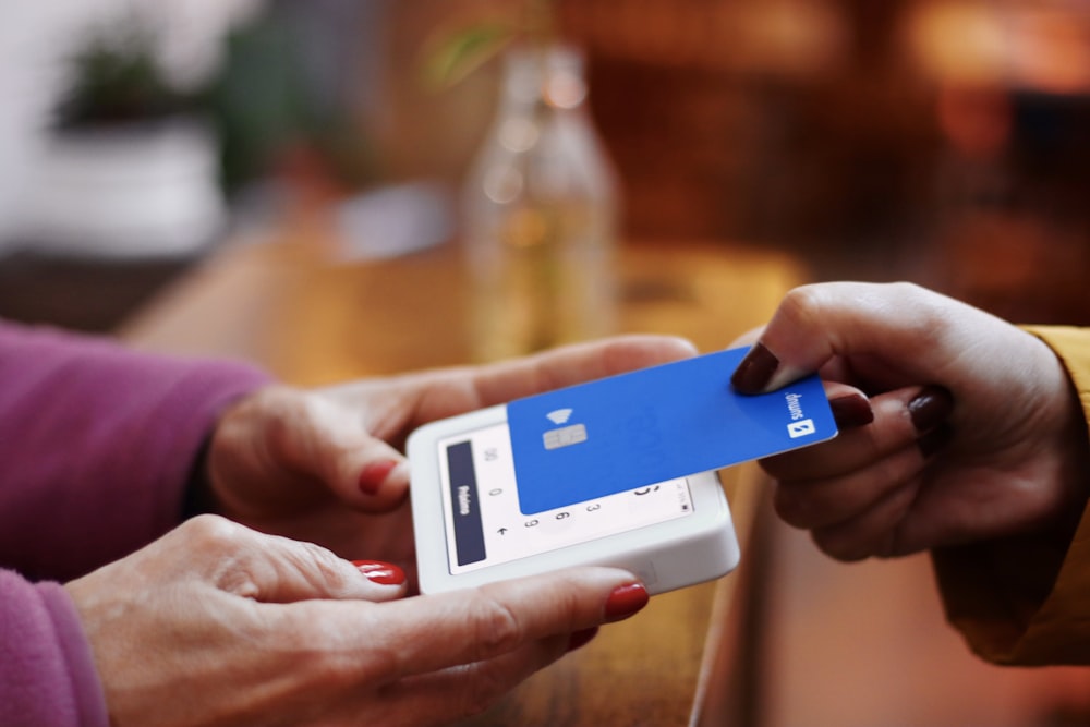 uma pessoa segurando um cartão de crédito e um telefone celular
