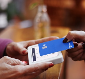 a person holding a credit card and a cell phone