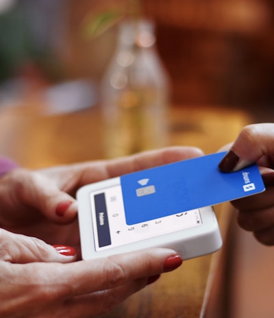 a person holding a credit card and a cell phone