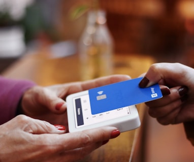 a person holding a credit card and a cell phone